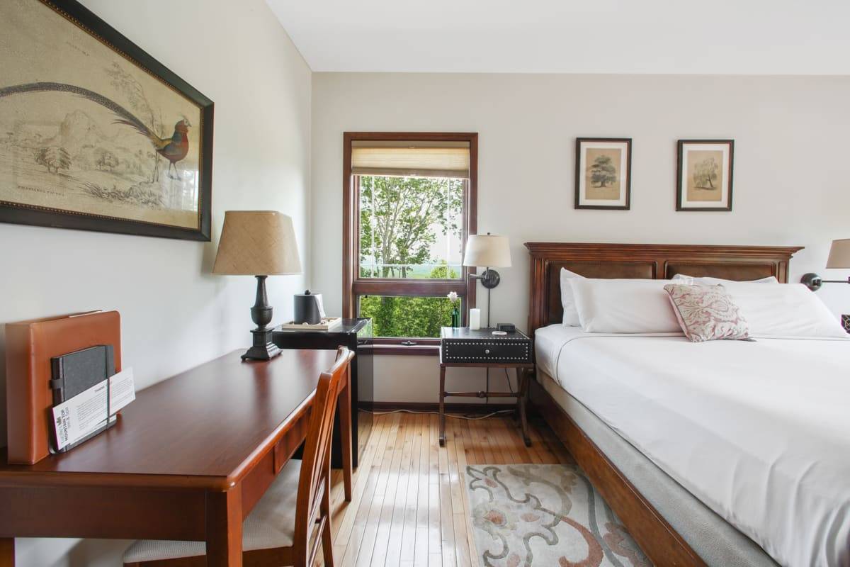 Close up of the King Bed with Light Green Bedspread with a window beside the bed