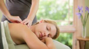 Blonde woman laying on her stomach getting a back massage